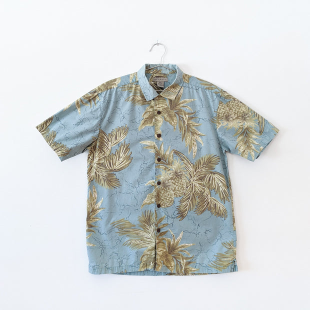 Retreat Short Sleeve Button-up Hawaiian Shirt. Light Teal Tropical Print Yellow and Green Pineapples. Brown Wood Buttons.