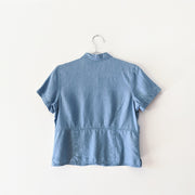 Back of a Light Indigo Blue t-shirt with visible waistline and darts for fitted style.