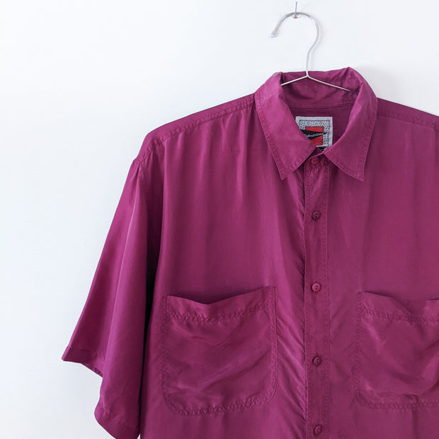 Vintage Reputation Silk Button-up Short Sleeve Shirt in Purple/Plum. Two Chest Pockets, Monochrome Buttons, Collar. Close-up.