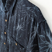 Bamboo Rayon/Cotton Button-up Short Sleeve Hawaiian Shirt. Black with Blue Leaf Print, Light Brown Buttons. Shoulder Close-up.