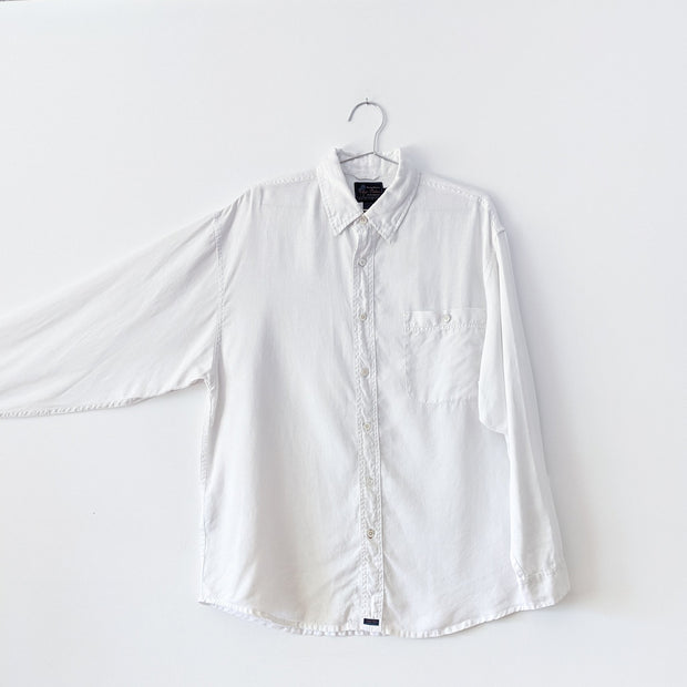 White linen button-down shirt with sleeve extended to show sleee width.