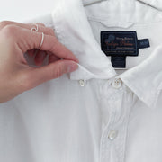 Close up of underside of button-down collar on white linen shirt.