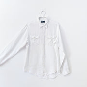 White linen long sleeve button-up shirt with two chest pockets that have button flaps, shown with the arm extended to indicate sleeve width.