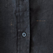 Detail of fabric imperfection on Black linen button-up shirt.