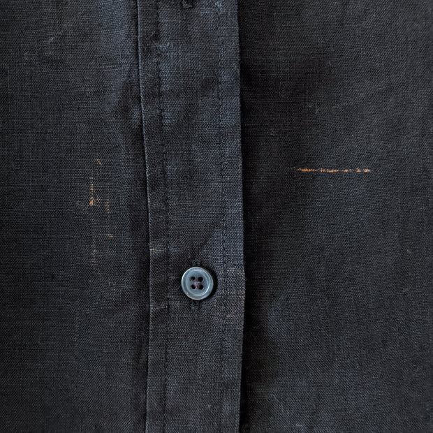 Detail of fabric imperfection on Black linen button-up shirt.