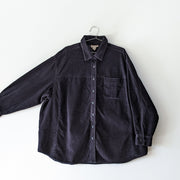 Black cotton corduroy button-up long sleece shirt, with the arm extended showing sleeve width. Cotton Ginny Plus, Secondhand clothing online in Canada from Fold and Fray.