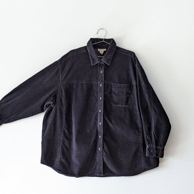 Black cotton corduroy button-up long sleece shirt, with the arm extended showing sleeve width. Cotton Ginny Plus, Secondhand clothing online in Canada from Fold and Fray.