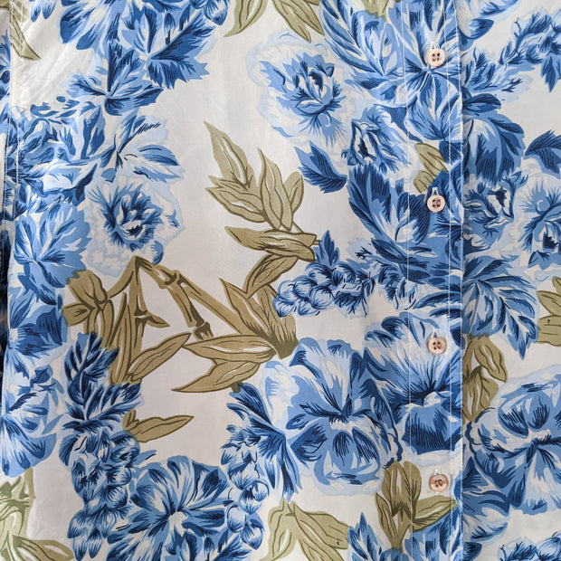 Vintage Jessie Blue Floral Button-up Long Sleeve Shirt. Close-up: Blue Flowers, Green Leaves, Off-White Background. Buttons.