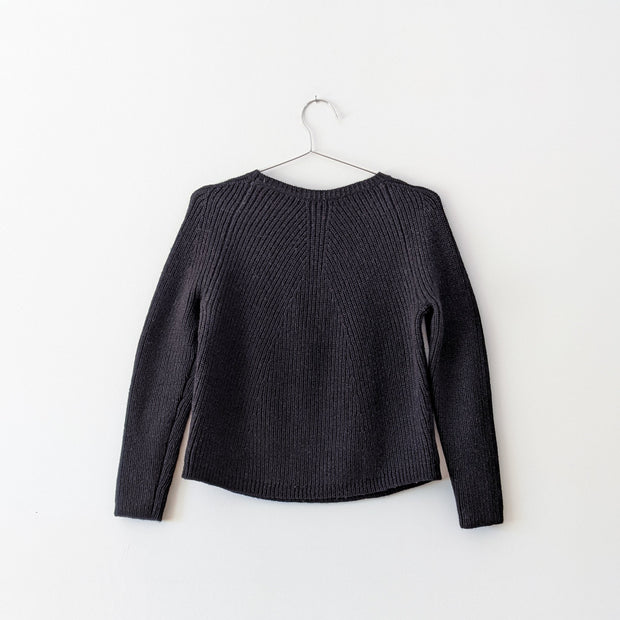 Black wool chunky knit sweater with crew neckline and vertical ribbing. Theory, Jaydee Fine Ultra, Medium. The back of the sweater.