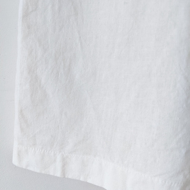 Close up of textured material (linen or cotton) at the bottom hem of off-White high-waist wide-leg crop pants. Secondhand natural fiber clothing from Fold and Fray.