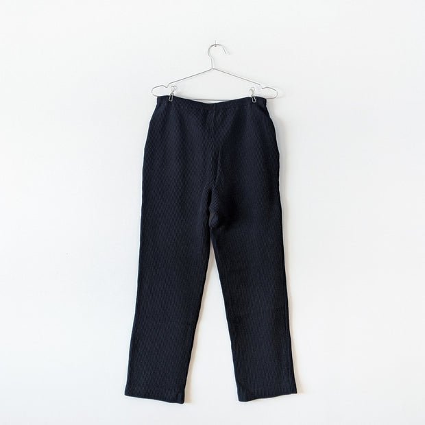 Back of Black vintage vertical-ribbed stretch cotton-knit pants with straight leg, narrow elastic waistband and side slash pockets. Jones New York. Secondhand from Fold and Fray.