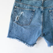 Distressed Denim on Back Left Pocket on Levi’s Cut-off Denim Shorts. High-rise Levi’s Signature Women’s Blue Jean Short.