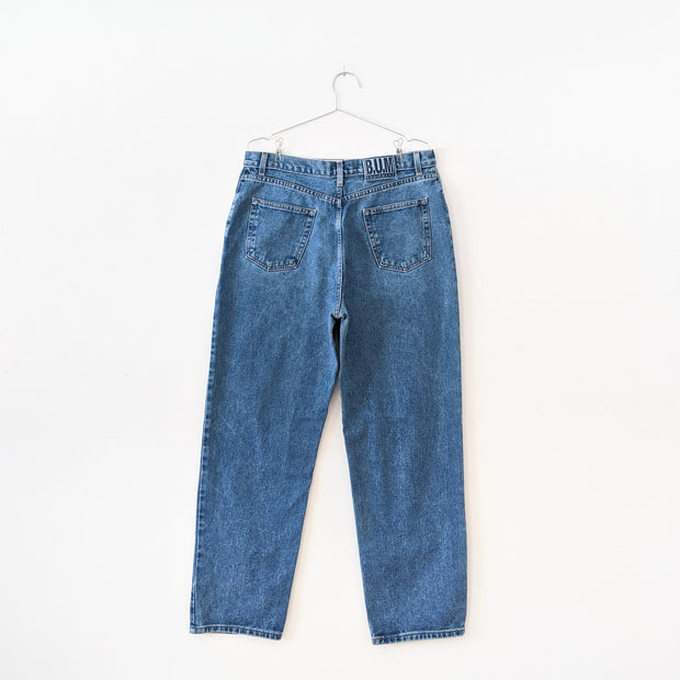 Vintage B.U.M. Equipment Blue Jeans. Solid Light-Medium Blue Wash, Tapered Leg. Women’s 18. Back of Jeans with Logo.