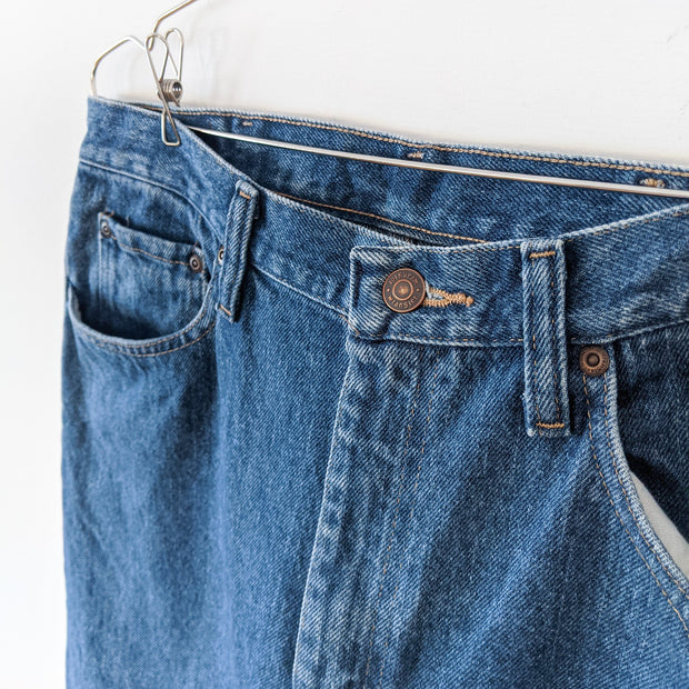 Angled Close-up of Front Pockets on Blue Denim Jeans, Men’s Wrangler 34x34 Five-Pocket Jean. Solid Dark Blue Wash.