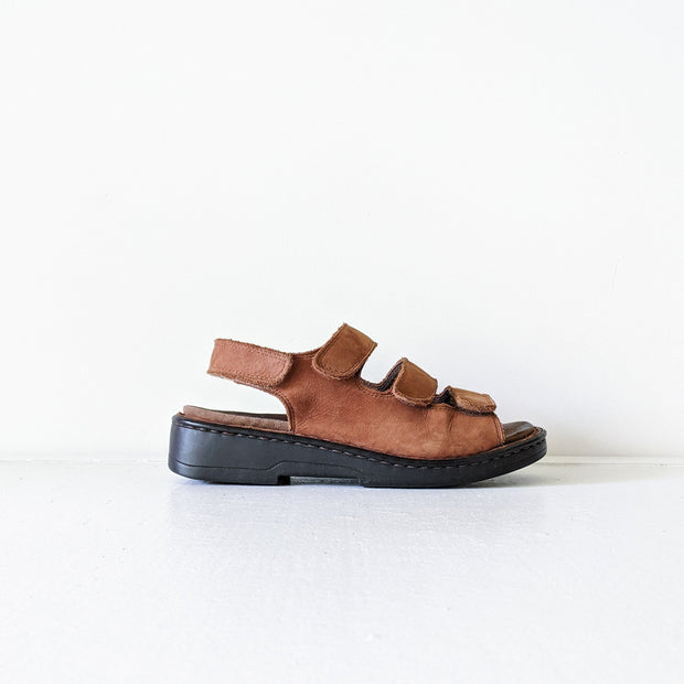 Deer Stags Brown Leather Slingback Sandals. Three Front Straps (Velcro), One Back Strap, Black Sole. Side View, One Sandal.