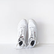 Birds-eye-view of White leather Reebok classic lace-up sneakers with white sole.