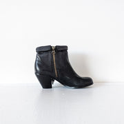 Side view of the instep of Black leather heeled ankle booties with almond toe. The top of the boot is shown roll down down, there is a gold metal utility zipper on the side of the instep. Sam Edelman Black Louie Boot 8M. Secondhand from Fold and Fray.