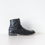 Side view of classic Black matte leather wingtip lace-up oxford boots. Above-the-ankle.