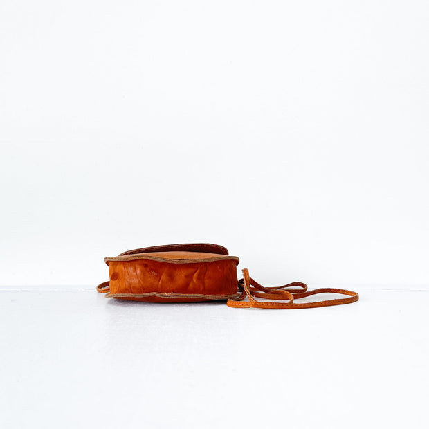 Hand Opening a Tan Leather Vintage Saddle Bag, Leather Vintage Purse with Flap. Golden Brown Leather Cross-body Bag.