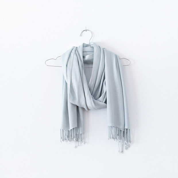 Pale Seafoam Green Scarf with Tassels, Looped over a Stainless Steel Hanger. Natural Fibre Clothing in Canada. Fold and Fray