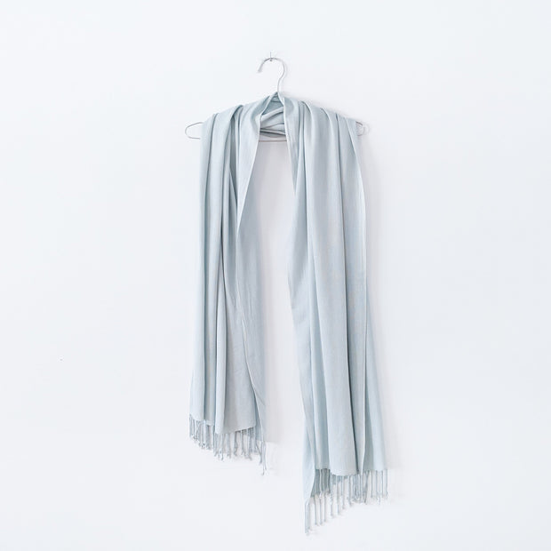 Pale Seafoam Green Scarf with Tassels, Hanging over a Stainless Steel Hanger. Natural Fibre Clothing in Canada. Fold and Fray