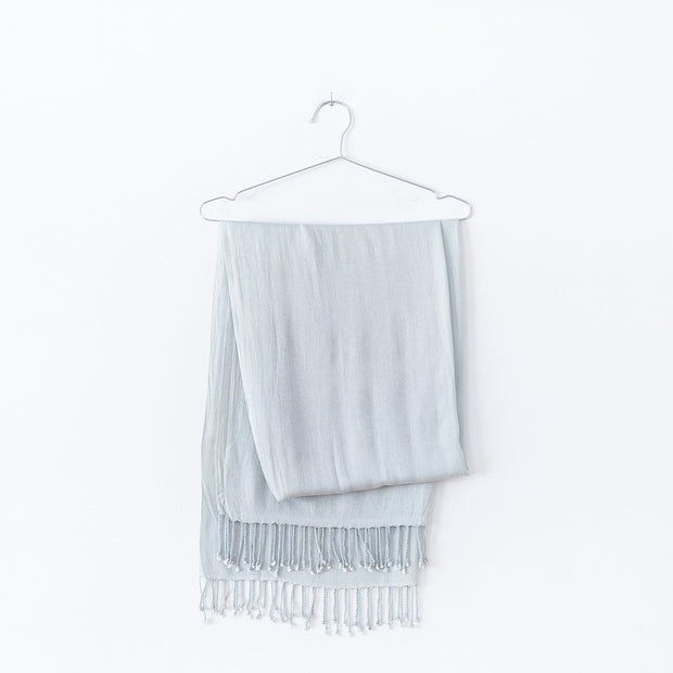 Pale Seafoam Green Scarf with Tassels, Folded over a Stainless Steel Hanger. Natural Fibre Clothing in Canada. Fold and Fray