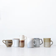 Eight Pieces Second-hand Vintage Pottery in Brown, White and Blue Colours. Lined up in a Row like a Morandi Portrait.