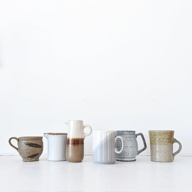 Eight Pieces Second-hand Vintage Pottery in Brown, White and Blue Colours. Lined up in a Row like a Morandi Portrait.