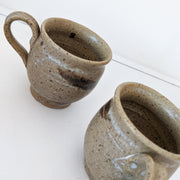 Two Small Brown Hanmade Ceramic Mugs. Mid-Tone Brown with White Marks and Dark Brown Brush Marks, Speckled.