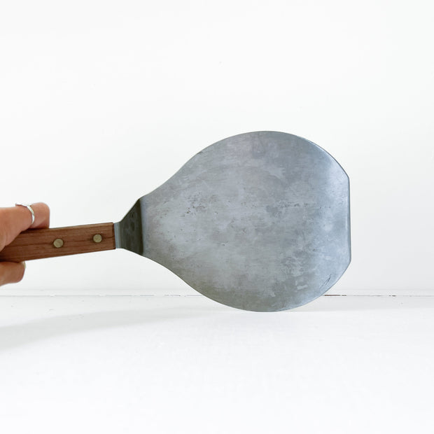 Top View of Used Stainless Steel Pizza Spatula, Pancake Server with Wooden Handle. Plastic-Free Home Goods. Guelph, Ontario, Canada.